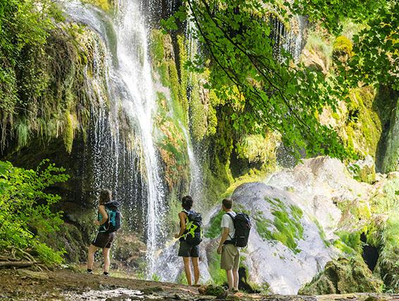 Randonneurs dans le Jura près d'une cascade
